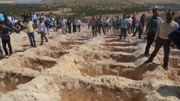People wait close to empty graves at a cemetery during the funeral for the victims of last night's attack on a wedding party that left 50 dead in Gaziantep in southeastern Turkey near the Syrian border on August 21, 2016 - Sputnik International