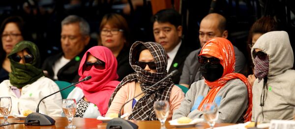 Family members of people alleged by police as drug pushers and were killed during an illegal drugs meth raid, wear masks during a Senate hearing regarding people killed during a crackdown on illegal drugs in Pasay, Metro Manila, Philippines August 23, 2016. Family members of people alleged by police as drug pushers and were killed during an illegal drugs meth raid, wear masks during a Senate hearing regarding people killed during a crackdown on illegal drugs in Pasay, Metro Manila, Philippines August 23, 2016. - Sputnik International