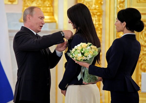 Russian President Vladimir Putin awards fencer Yana Egorian during a ceremony for Russian Olympic medallists returning home from the 2016 Rio Olympics, at the Kremlin in Moscow Russian President Vladimir Putin awards fencer Yana Egorian during a ceremony for Russian Olympic medallists returning home from the 2016 Rio Olympics, at the Kremlin in Moscow - Sputnik International