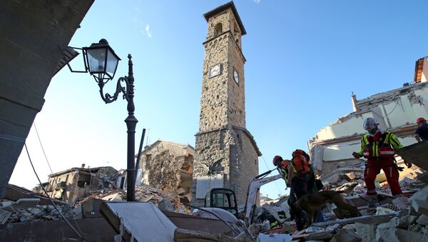 Rescuers walk past the bell tower with the clock showing the time of the earthquake in Amatrice, central Italy, August 24, 2016 - Sputnik International