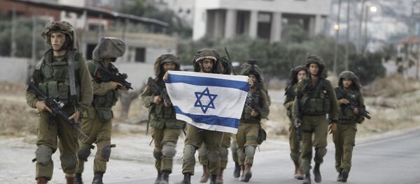 Israeli soldiers holding their national flag patrol a street in the West Bank village of Beit Furik, southeast of Nablus, early on June 20, 2014. - Sputnik International