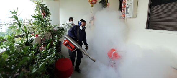 This photograph taken on August 28, 2016 and made available by the Straits Times shows workers fogging in the housing estate at Aljunied Crescent in Singapore - Sputnik International