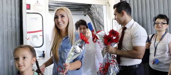 Turkish airport employees welcome Russian tourists after arriving on a charter flight on July 9, 2016 at Antalya airport in Antalya - Sputnik International