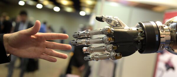 A man moves his hand toward SVH (Servo Electric 5 Finger Gripping Hand) automated hand made by Schunk during the 2014 IEEE-RAS International Conference on Humanoid Robots in Madrid on November 19, 2014 - Sputnik International