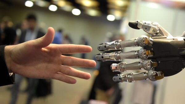 A man moves his hand toward SVH (Servo Electric 5 Finger Gripping Hand) automated hand made by Schunk during the 2014 IEEE-RAS International Conference on Humanoid Robots in Madrid on November 19, 2014 - Sputnik International