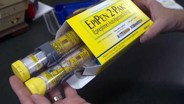 Pharmacist holds a package of EpiPens epinephrine auto-injector, a Mylan product, in Sacramento, Calif. (File) - Sputnik International