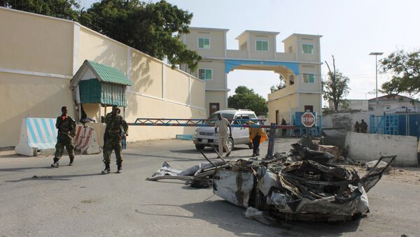 Somali soldiers walk past the wreckage of a car bomb by the main gate outside the presidential palace in Mogadishu (File) - Sputnik International