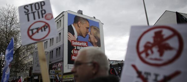 A man holds a poster with the slogan Stop TTIP as he passes a huge poster against TTIP with President Barack Obama and Chancellor Angela Merkel during a protest of thousands of demonstrators against the planned Transatlantic Trade and Investment Partnership, TTIP, and the Comprehensive Economic and Trade Agreement, CETA, ahead of the visit of United States President Barack Obama in Hannover, Germany, Saturday, April 23, 2016 A man holds a poster with the slogan Stop TTIP as he passes a huge poster against TTIP with President Barack Obama and Chancellor Angela Merkel during a protest of thousands of demonstrators against the planned Transatlantic Trade and Investment Partnership, TTIP, and the Comprehensive Economic and Trade Agreement, CETA, ahead of the visit of United States President Barack Obama in Hannover, Germany, Saturday, April 23, 2016 - Sputnik International