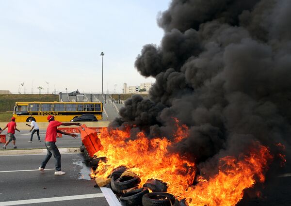A supporter of Brazil's suspended President Dilma Rousseff throws a traffic barrier to make a burning barricade to block a main avenue next to Arena Sao Paulo stadium, in Sao Paulo, Brazil August 30, 2016 - Sputnik International