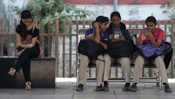 Indian women check their mobile telephones at a free Wi-Fi Internet zone in Mumbai (File) - Sputnik International