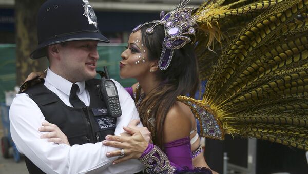 A performer dances with police during the Notting Hill Carnival in London, Britain August 29, 2016. - Sputnik International