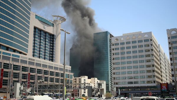 A general view shows smoke billowing from a 25-storey building under construction in a residential and commercial district of Abu Dhabi after a fire broke out on August 30, 2016. - Sputnik International