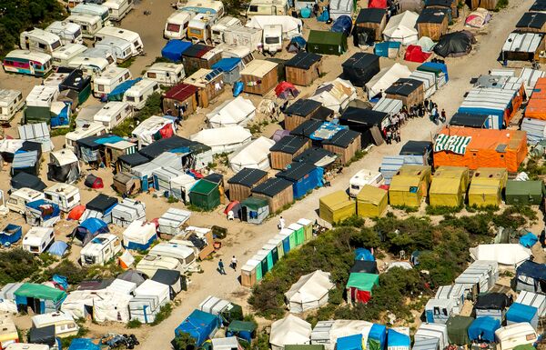 This aerial view taken on August 16, 2016, in Calais, northern France shows tents and people walking in the jungle camp where over 9000 migrants live according to different NGOs This aerial view taken on August 16, 2016, in Calais, northern France shows tents and people walking in the jungle camp where over 9000 migrants live according to different NGOs - Sputnik International