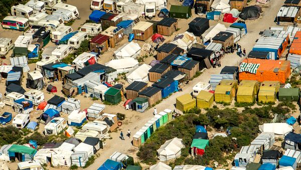 This aerial view taken on August 16, 2016, in Calais, northern France shows tents and people walking in the jungle camp where over 9000 migrants live according to different NGOs - Sputnik International