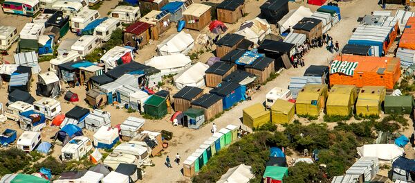This aerial view taken on August 16, 2016, in Calais, northern France shows tents and people walking in the jungle camp where over 9000 migrants live according to different NGOs This aerial view taken on August 16, 2016, in Calais, northern France shows tents and people walking in the jungle camp where over 9000 migrants live according to different NGOs - Sputnik International
