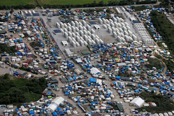 Aerial view of a makeshift camp as containers (rear) are put into place to house migrants living in what is known as the Jungle, a sprawling camp in Calais, France, August 14, 2016.  - Sputnik International