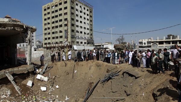 Yemenis gather around a crater caused by a Saudi-led airstrike that targeted a building in the centre of the capital Sanaa (File) - Sputnik International