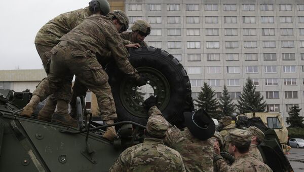 US army soldiers roll a tyre from top of a stryker armored vehicle during a stop of his convoy in Prague, Czech Republic, Tuesday, March 31, 2015 - Sputnik International