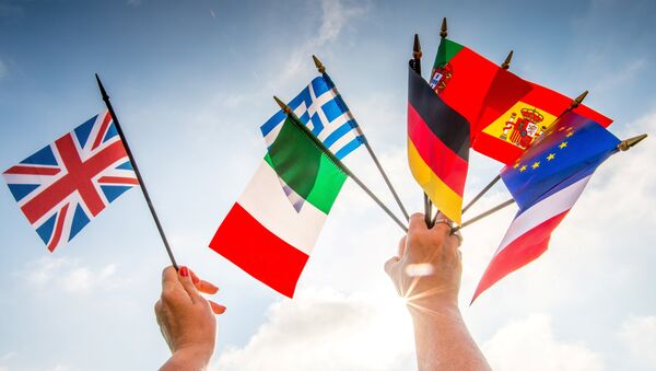 A person holds European country flags in an hand and a United Kingdom flag in another. - Sputnik International