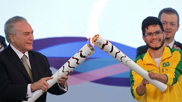 Brazil's acting President Michel Temer, left, lights the torch of Paralympic athlete Yohansson Nascimento during a ceremony for 2016 Rio Paralympic Games at the Planalto Presidential Palace, in Brasilia, Brazil, Thursday, Aug. 25, 2016. - Sputnik International