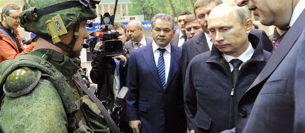 Russian President Vladimir Putin, second left, reviews examples of 'Ratnik' modern military garment during a working visit to OJSC 'Kalashnikov Concern' in Izhevsk. Center - Russian Denfence Minister Sergei Shoigu. - Sputnik International
