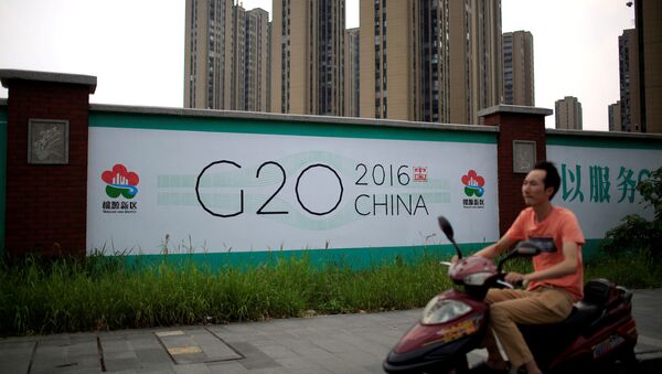 A man rides an electronic bike past a billboard for G20 summit in Hangzhou, Zhejiang province, China - Sputnik International