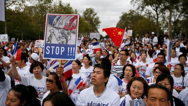 Demonstrators hold signs at a rally of the Chinese community to raise awareness about recent racists attacks in Paris, France, September 4, 2016. - Sputnik International