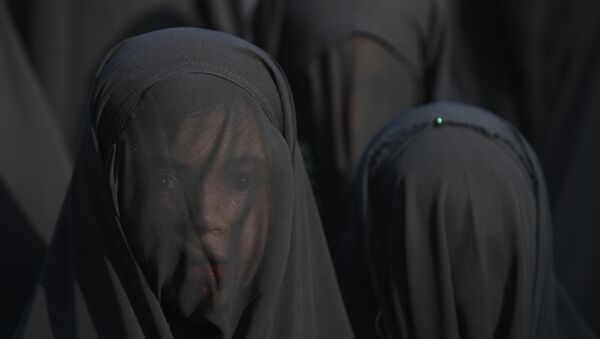 An Iraqi Shiite girl, whose face is covered with a veil, takes part in a parade in preparation for the peak of the mourning period of Ashura in Baghdad's northern district of Kadhimiya on October 22, 2015 - Sputnik International