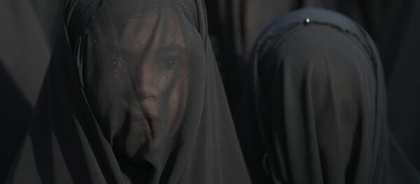 An Iraqi Shiite girl, whose face is covered with a veil, takes part in a parade in preparation for the peak of the mourning period of Ashura in Baghdad's northern district of Kadhimiya on October 22, 2015 - Sputnik International