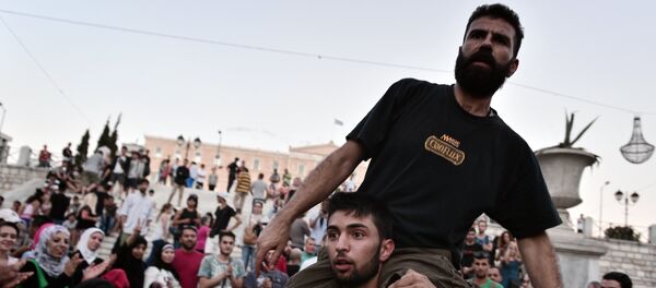 Refugees with their children protest in front of the Greek parliament in Athens Refugees with their children protest in front of the Greek parliament in Athens - Sputnik International