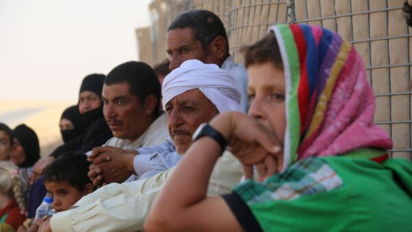 Iraqi families who fled Hawijah in northern Iraq, gather after arriving in the Kirkuk province, about 200 km north of the capital Baghdad, on August 7, 2016 - Sputnik International