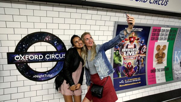 Passengers pose for a selfie as they wait for the Night Tube train service at Oxford Circus on the London underground system in London, Britain August 20, 2016. - Sputnik International
