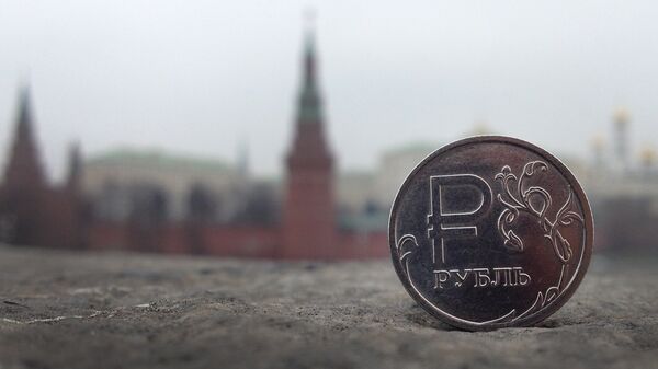 A Russian rouble coin is pictured in front of the Kremlin in central Moscow on 6 November 2014. - Sputnik International