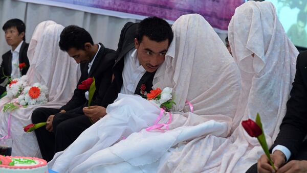 In this photograph taken on October 10, 2014, an Afghan groom (C) talks with his bride during a mass wedding ceremony in which one hundred couples were married on the outskirts of Kabul - Sputnik International