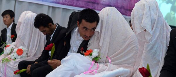 In this photograph taken on October 10, 2014, an Afghan groom (C) talks with his bride during a mass wedding ceremony in which one hundred couples were married on the outskirts of Kabul - Sputnik International