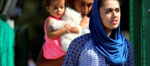 Migrants board a bus at an open migrant camp in Vamosszabadi, Hungary on August 30, 2016. Picture taken on August 30, 2016. - Sputnik International