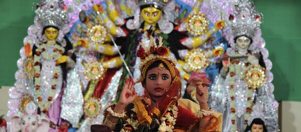 A young Indian Hindu unmarried girl, Nilanjana Chakraborty (5), known as a 'kumari' and dressed as the Hindu goddess Durga, puts her hand up during a ritual for the Durga Puja festival at Ramakrishna Mission in Agartala, the capital of northeastern state of Tripura on October 21, 2015 A young Indian Hindu unmarried girl, Nilanjana Chakraborty (5), known as a 'kumari' and dressed as the Hindu goddess Durga, puts her hand up during a ritual for the Durga Puja festival at Ramakrishna Mission in Agartala, the capital of northeastern state of Tripura on October 21, 2015 - Sputnik International