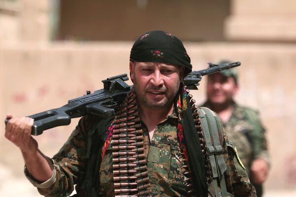 A Kurdish fighter from the People's Protection Units (YPG) carries his weapons as he walks along a street in the northeastern city of Hasaka, Syria, August 21, 2016. A Kurdish fighter from the People's Protection Units (YPG) carries his weapons as he walks along a street in the northeastern city of Hasaka, Syria, August 21, 2016. - Sputnik International