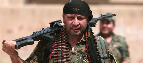 A Kurdish fighter from the People's Protection Units (YPG) carries his weapons as he walks along a street in the northeastern city of Hasaka, Syria, August 21, 2016. A Kurdish fighter from the People's Protection Units (YPG) carries his weapons as he walks along a street in the northeastern city of Hasaka, Syria, August 21, 2016. - Sputnik International