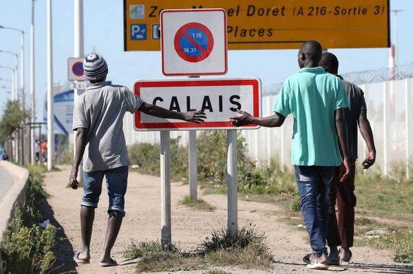 Migrants pass by a road sign as they leave the northern area of the camp called the Jungle in Calais, France, September 7, 2016 Migrants pass by a road sign as they leave the northern area of the camp called the Jungle in Calais, France, September 7, 2016 - Sputnik International