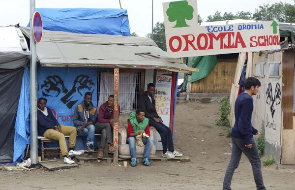 Migrants stand under makeshift shelters in the northern area of the camp called the Jungle in Calais, France, September 6, 2016 Migrants stand under makeshift shelters in the northern area of the camp called the Jungle in Calais, France, September 6, 2016 - Sputnik International