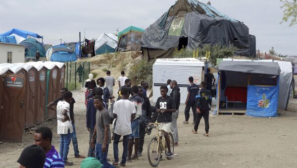 Migrants walk in the northern area of the camp called the Jungle in Calais, France, September 6, 2016 - Sputnik International