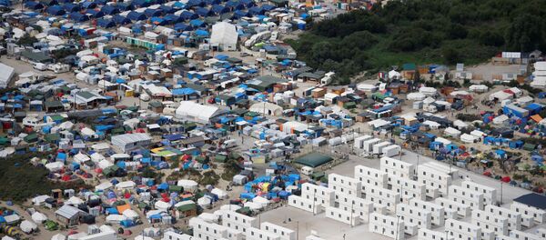 Aerial view of a makeshift camp as containers (front) are put into place to house migrants living in what is known as the Jungle, a sprawling camp in Calais, France, August 14, 2016 - Sputnik International