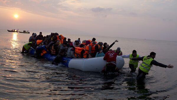  In this Sunday, March 20, 2016 file photo, volunteers help migrants and refugees on a dingy as they arrive at the shore of the northeastern Greek island of Lesbos, after crossing the Aegean sea from Turkey. - Sputnik International