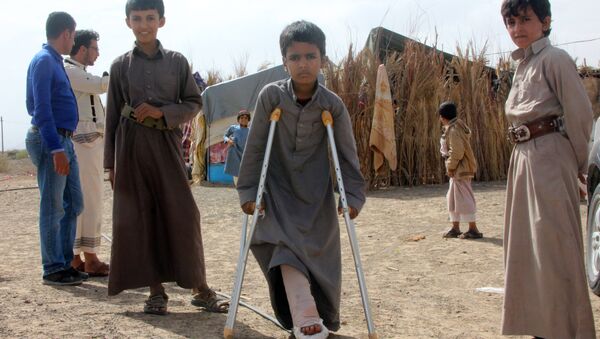 Mabruk Mughrabi (C), a Yemeni boy injured in his leg as a result of a land mine, stands with friends at a camp for internally displaced on the outskirts of Marib on April 15, 2016 - Sputnik International