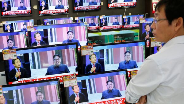 A sales assistant watches TV sets broadcasting a news report on North Korea's fifth nuclear test, in Seoul, South Korea, September 9, 2016. - Sputnik International