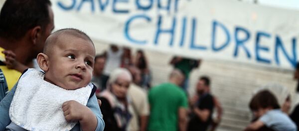 This file photo taken on September 02, 2016 shows refugees with their children protesting if front of the Greek parliament in Athens, calling for faster relocation program and opening of the borders. - Sputnik International