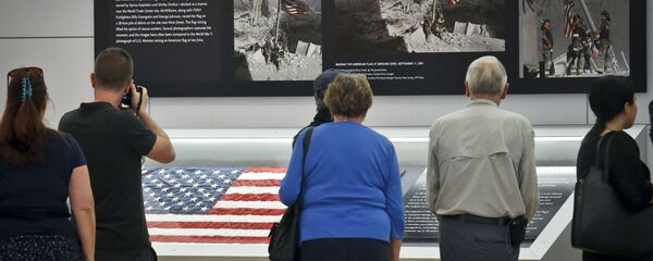 Visitors view the display for the American flag, left, that firefighters hoisted at ground zero in the hours after the 9/11 terror attack at the Sept. 11 museum in New York Visitors view the display for the American flag, left, that firefighters hoisted at ground zero in the hours after the 9/11 terror attack at the Sept. 11 museum in New York - Sputnik International