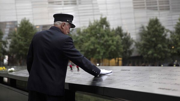 A member of the New York Fire Department places his hand on the memorial before a ceremony marking the 14th anniversary of the 9/11 attacks, at the National September 11 Memorial and Museum in Lower Manhattan in New York - Sputnik International