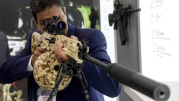 A visitor reviews an RPK-16 light machine rifle at the Kalashnikov pavilion, at the ARMY 2016 International Military Forum, at the exhibition center of the Patriot Military Park of the Russian Armed Forces in the Moscow Region. - Sputnik International